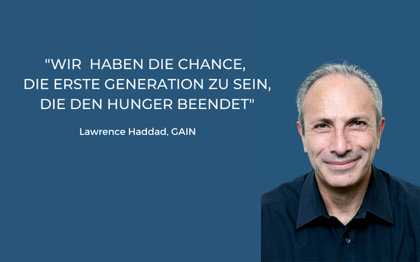 Ein Mann lächelt neben einem inspirierenden Zitat über die Beendigung des Hungers im Einklang mit der Natur.