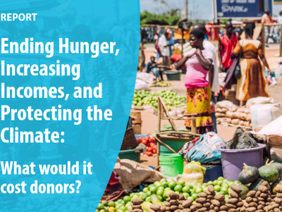 Menschen kaufen auf einem geschäftigen Markt ein, während ein Bericht über Hunger und Klimaschutz präsentiert wird.