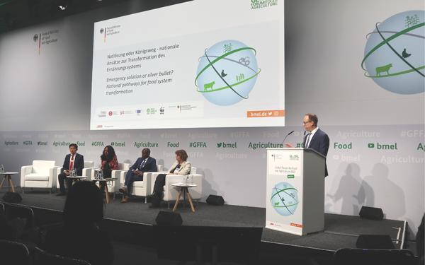 Ein Redner spricht auf einem Podium vor einem Panel beim Global Forum für Ernährung und Landwirtschaft 2023.