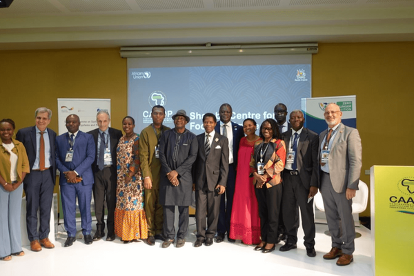 Eine Gruppe von Menschen posiert vor einem Projektorbildschirm bei einer Konferenz des CAADP für Ernährungssicherheit.
