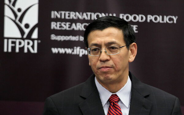 Ein Mann in Anzug und Krawatte steht vor einem Banner des International Food Policy Research Institute.