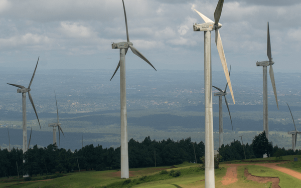 Windkraftanlagen drehen sich in einer ländlichen Landschaft unter bewölktem Himmel und erzeugen grüne Energie.