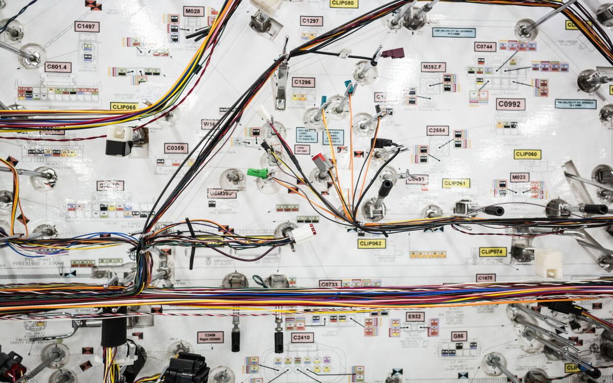 Ein komplexes Netzwerk aus farbigen Kabeln und Schaltern ist auf einem technischen Schaltplan angeordnet.
