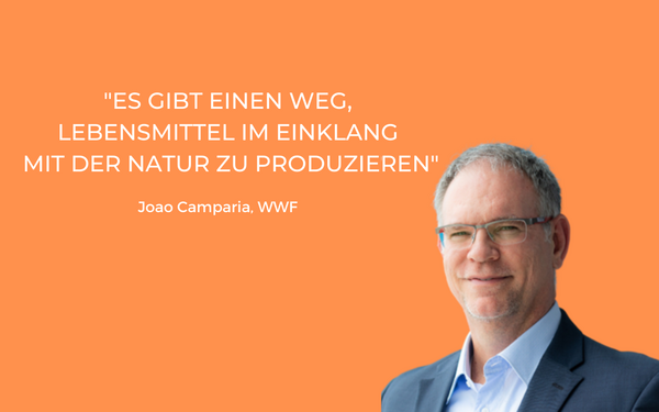 Ein Mann in Anzug steht vor orangefarbenem Hintergrund mit einem Zitat über nachhaltige Lebensmittelproduktion.