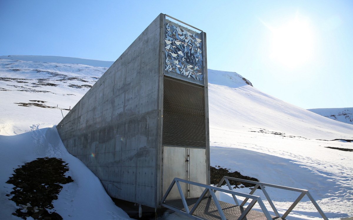Der Svalbard Global Seed Vault liegt eingebettet in eine verschneite Landschaft, seine futuristische Fassade strahlt in der Sonne.