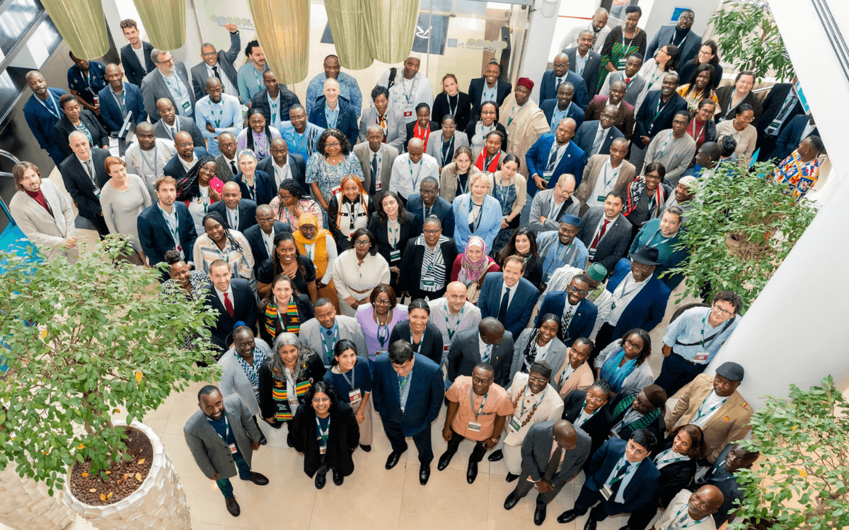 A large group of diverse individuals gathers at the NELGA closing workshop in Addis Ababa, surrounded by greenery indoors.