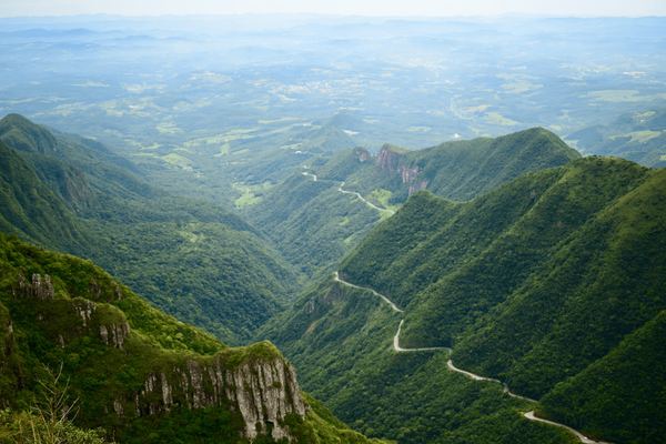 Eine kurvenreiche Straße schlängelt sich durch üppig grüne Berge und bietet einen beeindruckenden Blick auf die Landschaft.