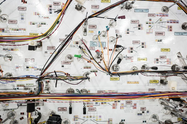 Ein komplexes Netzwerk aus farbigen Kabeln und Schaltern ist auf einem technischen Schaltplan angeordnet.