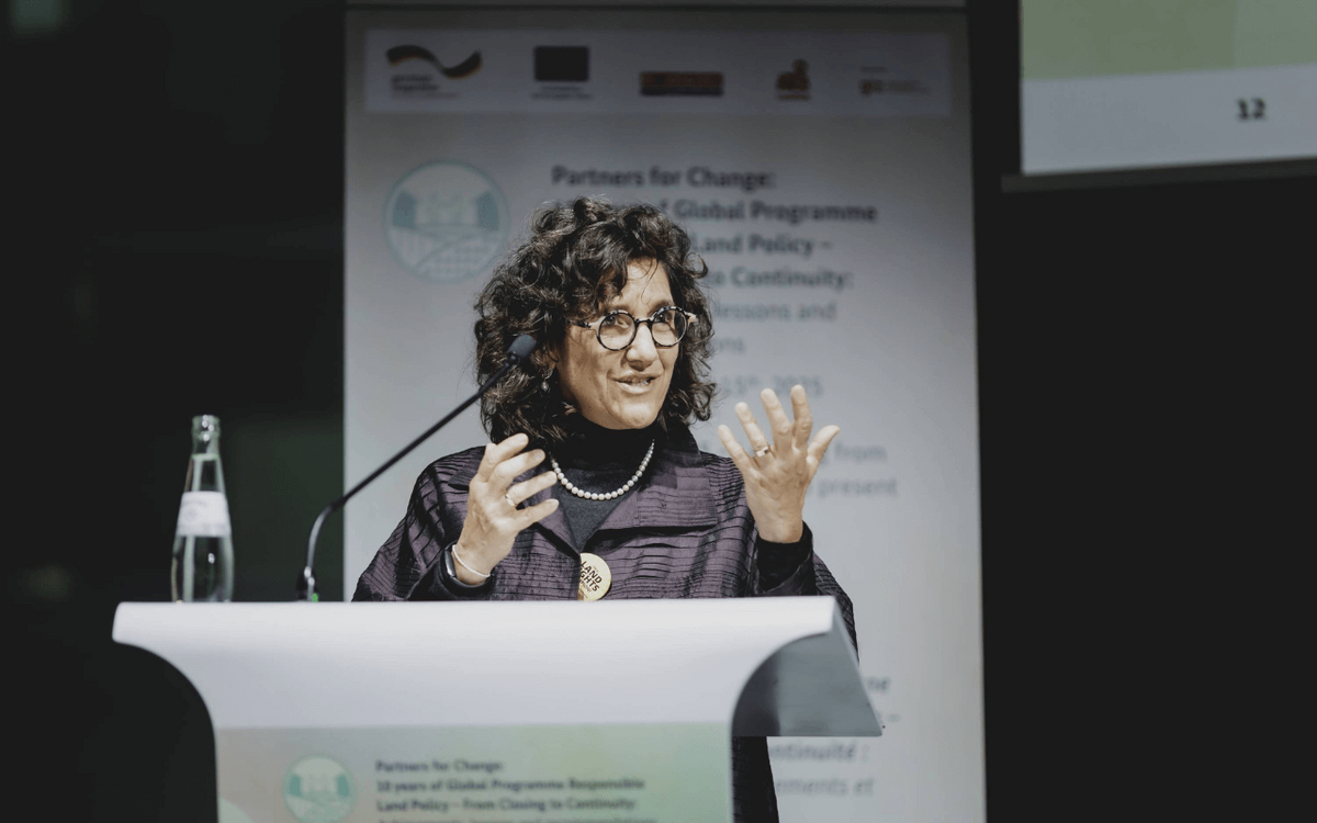 A woman speaks passionately at a podium during a panel at GIZ Land Week 2025, highlighting international land issues.